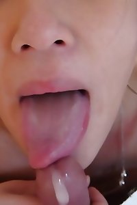 an asian girl is sucking a giant cock and putting it in her mouth